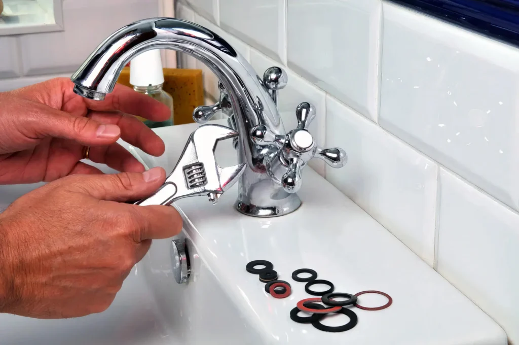 Plumber performing maintenance on a bathroom faucet in Colorado Springs