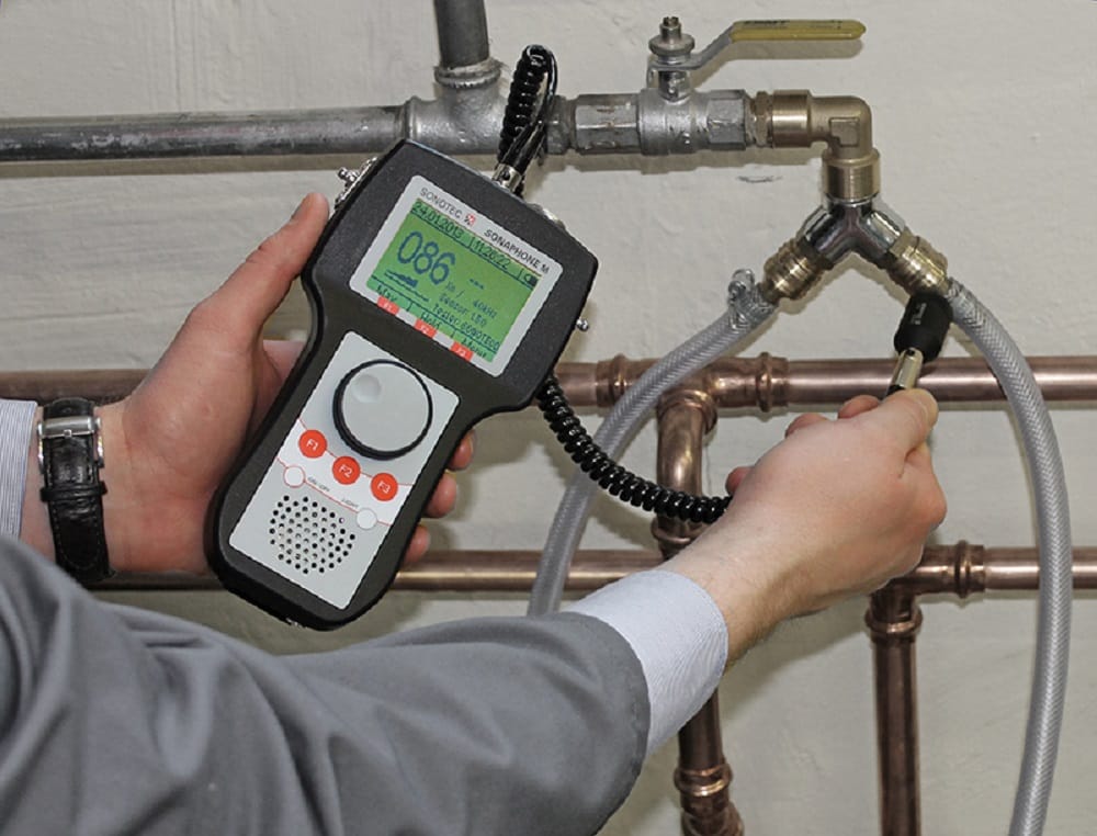 Plumber testing pipes with electronic leak detection equipment in Colorado Springs