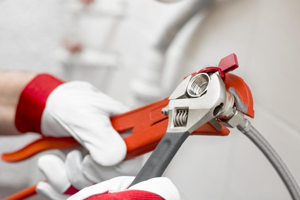 Plumber holding pipe wrenches for an emergency repair in Colorado Springs
