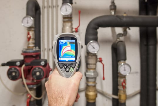 Plumber using a thermal imaging camera to inspect pipes in Colorado Springs