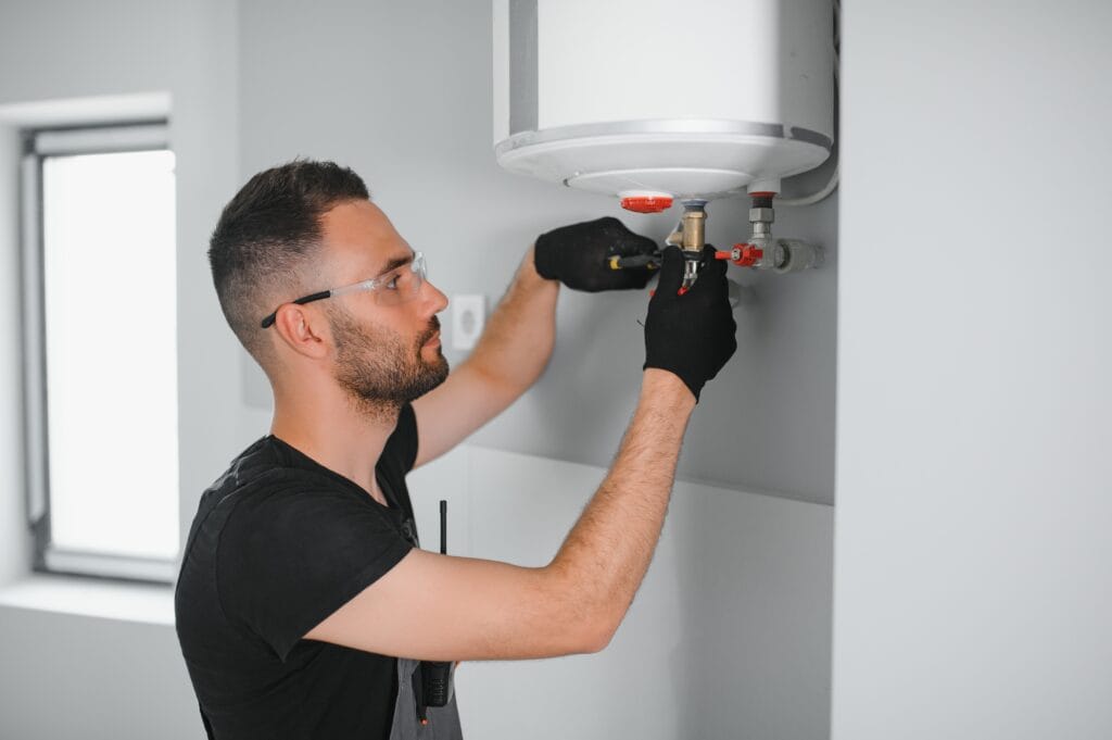 Technician performing water heater maintenance in Colorado Springs