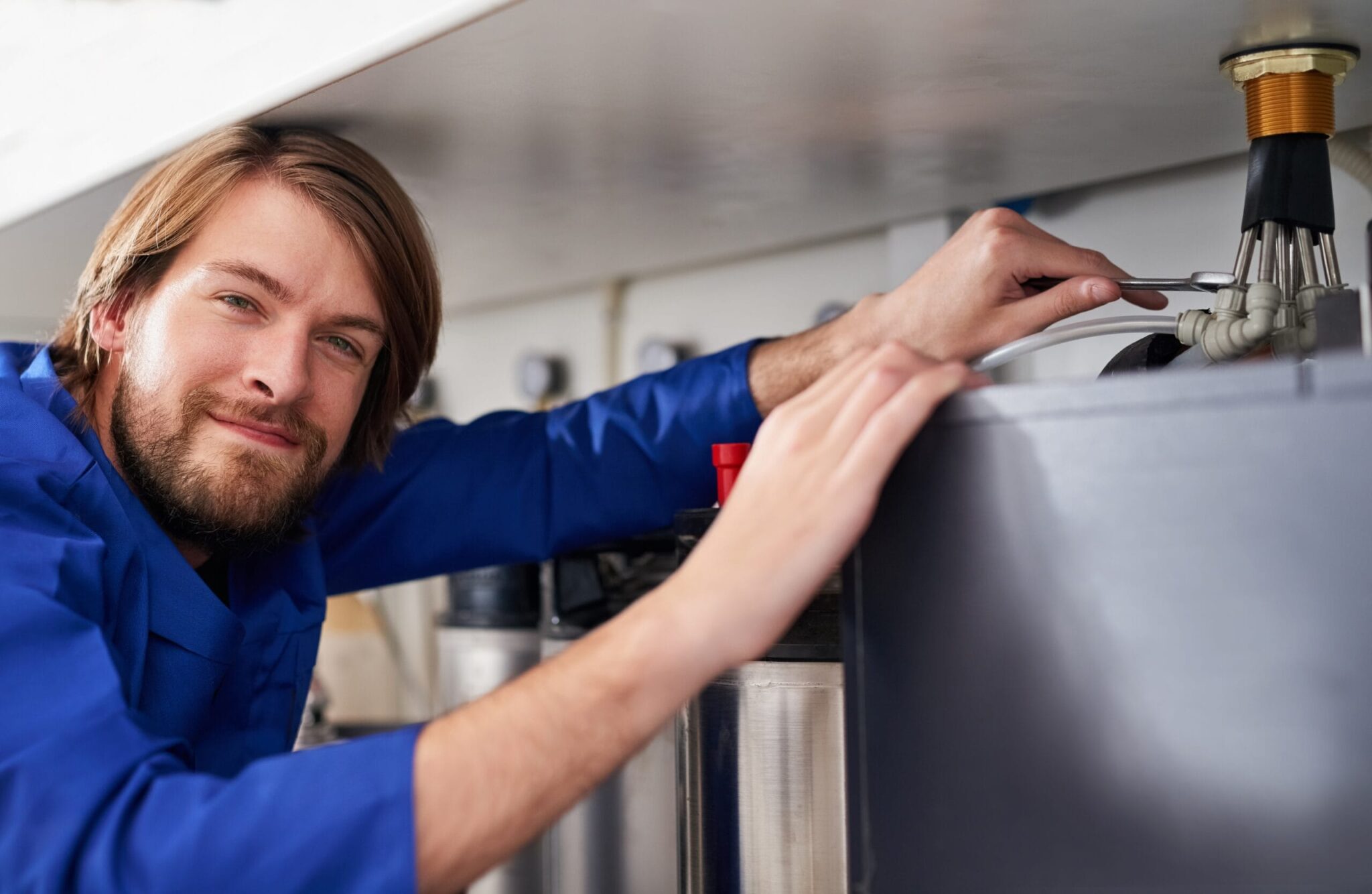 Technician servicing a residential water heater tank in Colorado Springs